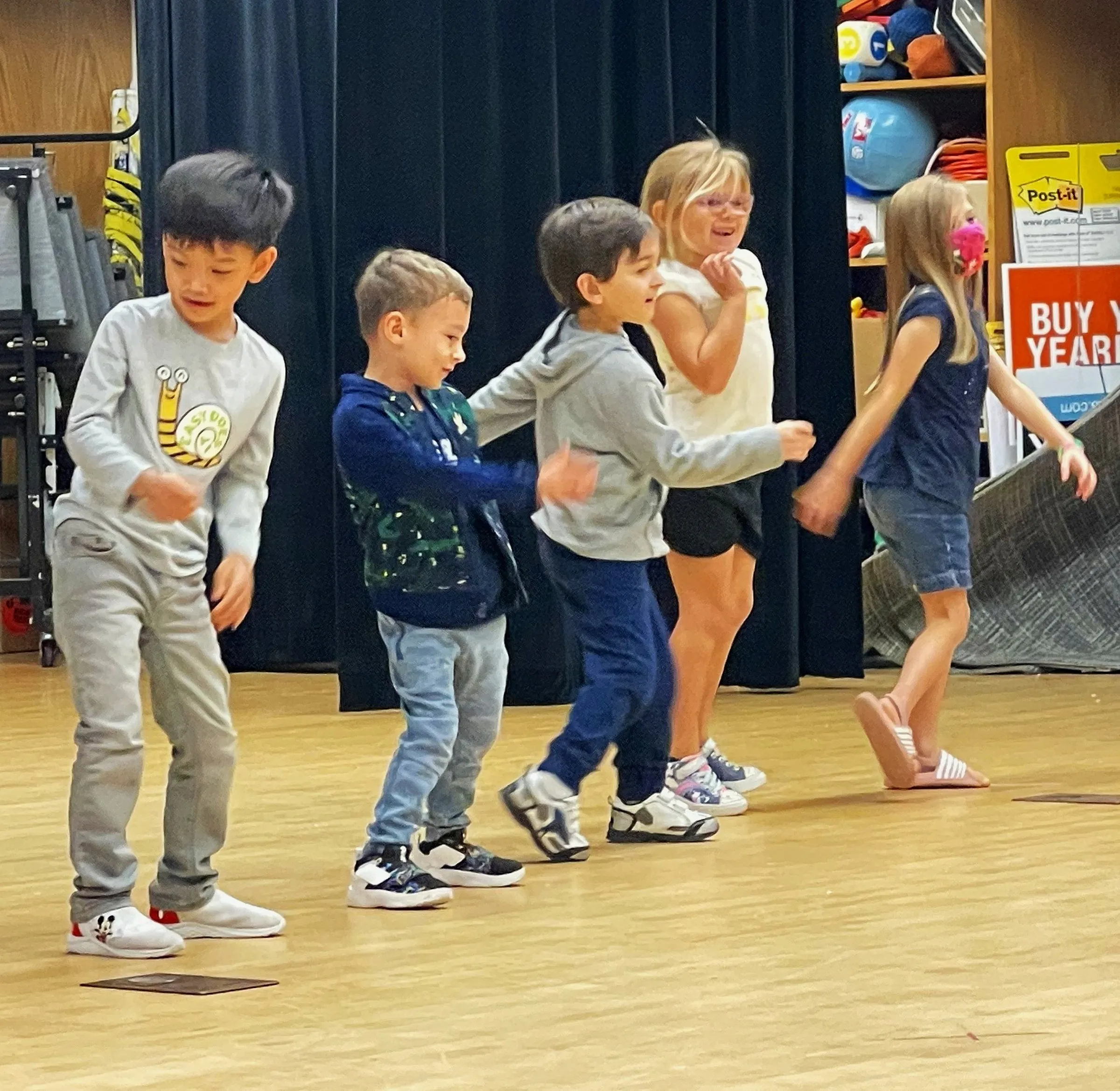 Simone dancing with young students in a classroom