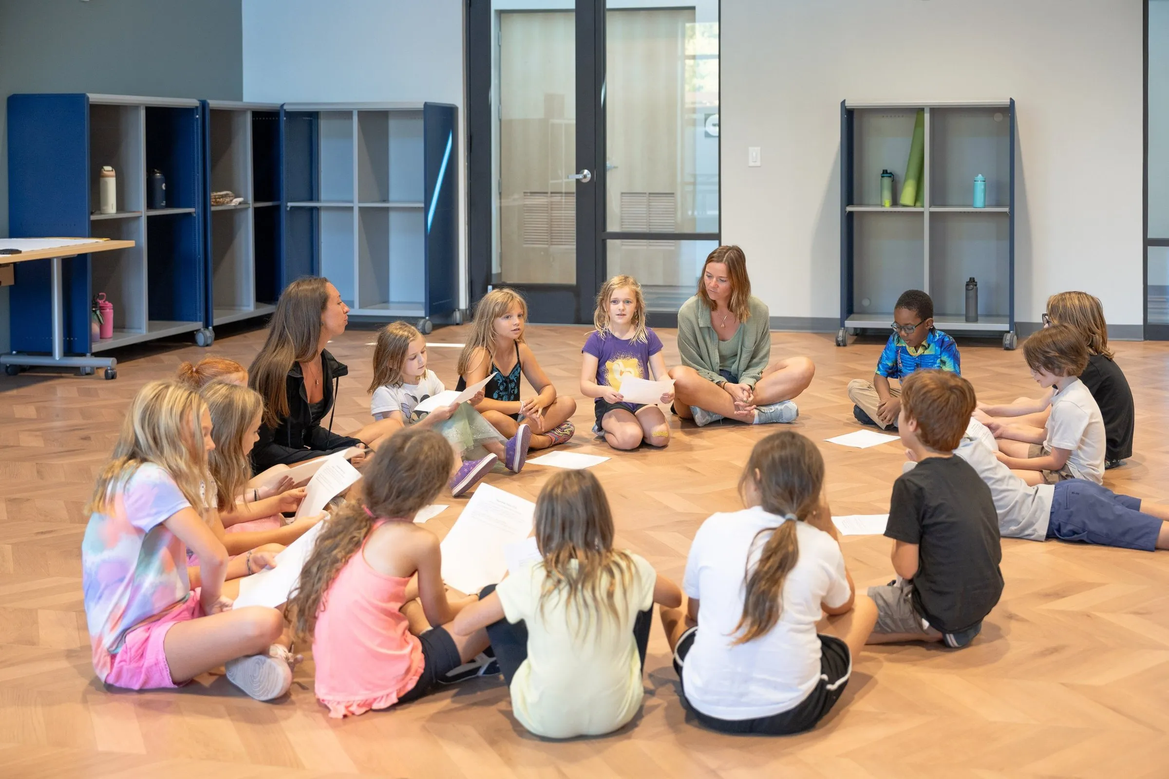 Students sitting in a circle on the floor during a class with Simone